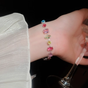 Detailed view of a silver bracelet with colorful zircon stones on a model's wrist