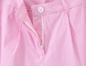 Dettaglio della vita dei pantaloni a righe rosa con bottone bianco e cerniera