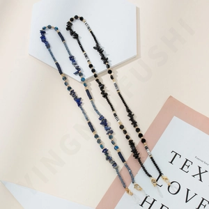 Detail of beaded eyewear chain with natural blue and black stones and golden clasps