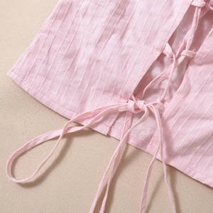 Dettaglio del top a fascia rosa in tessuto di cotone e lino a righe traspirante con lacci
