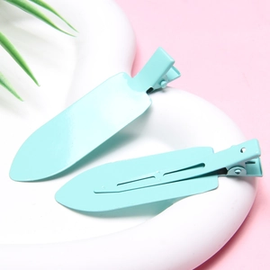 Close-up of two light blue seamless hair clips on a tray for crease-free styling