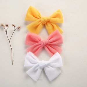 Detailed view of lightweight mesh bow hair clips in yellow, pink, and white colors