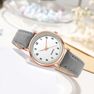 Detail view of quartz watch with rose gold case, white dial and grey suede strap