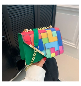 Detail of color-block crossbody bag featuring geometric prints and gold chain strap