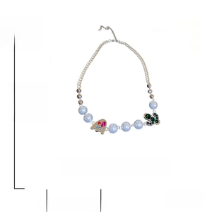 Detailed macro view showing the alloy chain, crystal ghost, and cactus charms on necklace