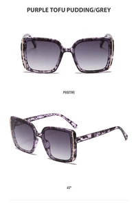 Detail view of square marble texture sunglasses with purple pattern and gold metal trim