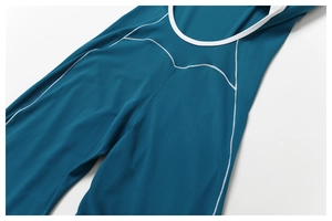 Detail der weißen Kontrastnähte auf einem marineblauen, rückenfreien Yoga-Jumpsuit