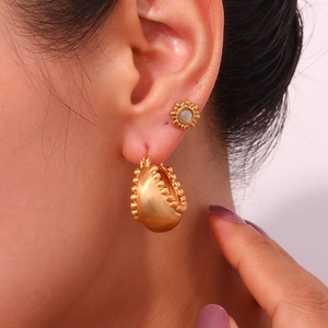 Macro view of gold plated sunflower stud earrings featuring opal center and beaded edge detail