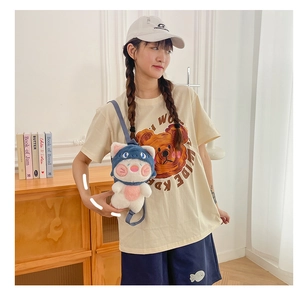 Detail of plush animal backpack with cute blue hat and soft texture on female model