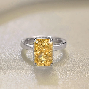 Macro shot of rectangular yellow gemstone ring with pavé diamonds on silver band