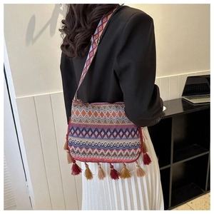 Ethnic crossbody bag with geometric woven patterns and fringe tassels on a model