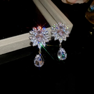 Detailed close-up of zircon wheat flower and teardrop earrings in polished silver finish