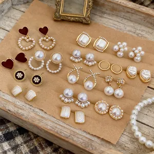 Vintage luxury earring set with pearls and diamonds on a French style wooden tray display