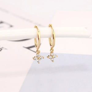 Macro view of gold flower earrings with pavé zircons and polished mirror finish