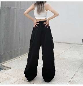 Back view of high waisted black cargo pants featuring elastic waistband and relaxed wide leg cut