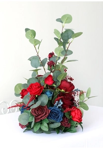 Detail of red and blue faux roses with eucalyptus leaves for wedding centerpiece decor