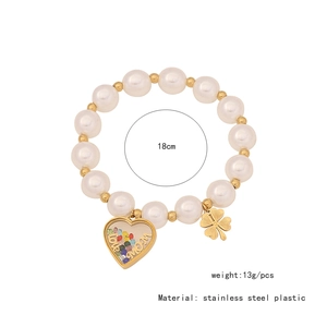 Detail of beaded pearl bracelet with gold clover and heart pendant showing 18cm length