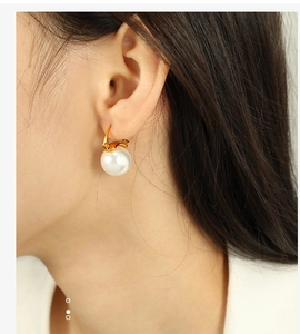 Vue détaillée de la boucle d'oreille en perle blanche avec crochet doré élégant