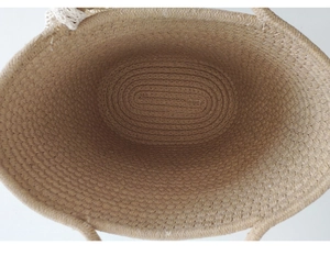 Top view of the spacious khaki woven straw bag interior with white lace trim detail
