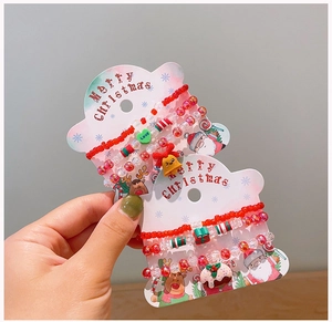 Detail of Christmas beaded bracelet set with bells and gingerbread charms on card