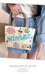 Detail of mini canvas tote bag with winter themed cartoon prints and brown handles