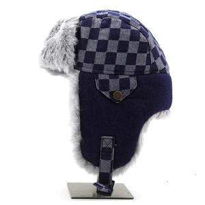 Detail of winter trapper hat with checkerboard pattern, faux fur lining and side pocket