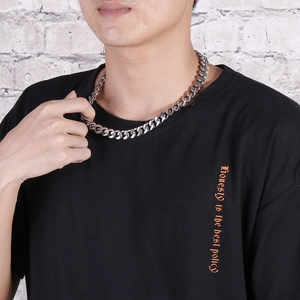 Silver stainless steel Cuban link necklace worn by a male model for a street style look