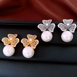Macro view of mesh clover earrings with 18K gold plating, zircons, and white pearls