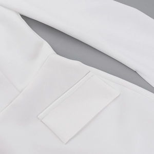 Détail de la texture du tissu tissé blanc sur le poignet et finitions de couture