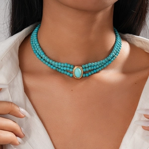 Detail of three-layer bohemian turquoise beaded choker necklace on model neck