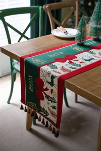 Detailed Christmas table runner with tassels, woven reindeer patterns, and holiday motifs