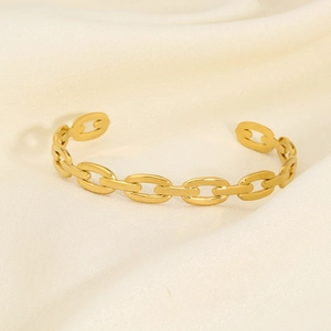 Detailed view of the gold chain link open bracelet on soft beige silk background