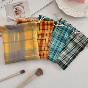 Close-up of four colorful plaid drawstring pouches for jewelry and makeup storage