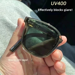 Detail view of UV400 protective lens on folding sunglasses with dark green frames