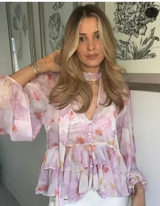 Detail of pink floral chiffon top with romantic ruffled sleeves and V-neckline choker