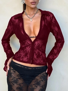 Detailed close-up of wine red lace fabric and deep V-neck design on long sleeve shirt