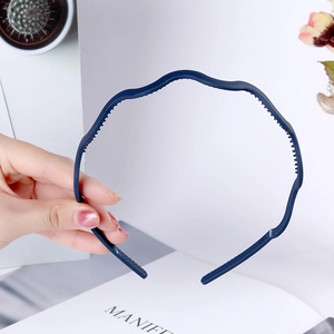 Detailed close-up of dark blue wave-shaped plastic headband with non-slip inner teeth