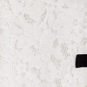 Elegant white lace shirt featuring floral embroidery and black ribbon bow tie detail