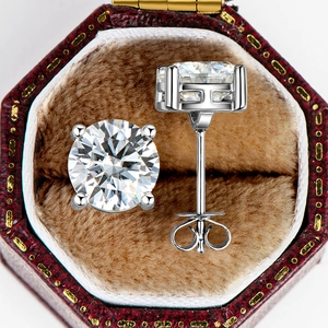Close-up of 2 carat moissanite stud earrings in a four-prong setting and vintage red box
