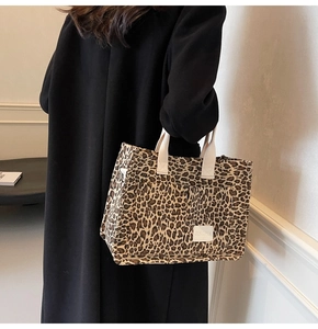 Close-up of leopard print canvas tote bag featuring JINGPIN logo and white handle straps