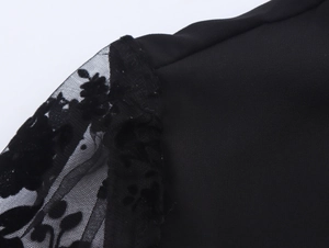 Dettaglio dell'elegante patchwork in pizzo nero e ricami floreali sulla spalla