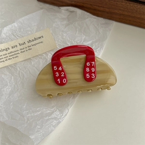 Detail of tulip hair claw clip with beige marble texture and red number print design