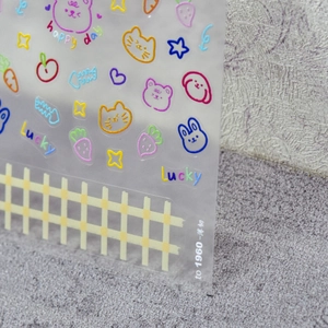 Macro detail of transparent nail stickers with cute cartoon cats and rabbits for manicure