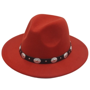 Détail d'un chapeau fedora rouge avec bande en cuir noir et boucles métalliques argentées