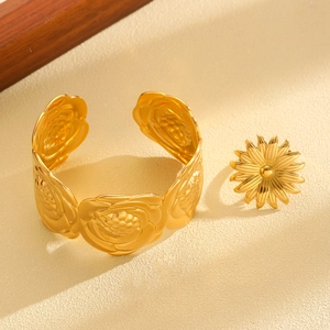 Detailed view of the gold floral jewelry set with relief rose bangle and sunflower ring