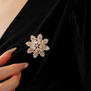 Sparkling snowflake brooch in gold-plated metal with marquise zircons on black velvet