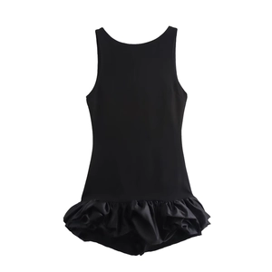 Detail shot of black sleeveless mini dress featuring a tiered ruffle hem and silky texture