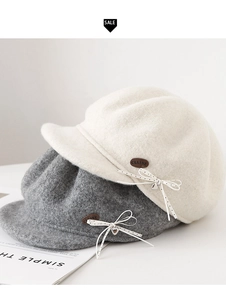 Detail of wool octagonal newsboy hats featuring polka dot bows and metallic heart pendants