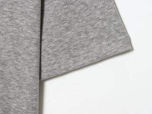 Detail of grey knitted cotton fabric showing high-quality double-needle stitching on the hem