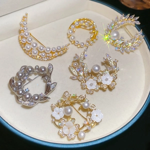 Detailed set of 18k gold plated flower brooches with zircons and pearls on velvet